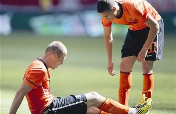 Arjen Robben (sedi) si s soigralcem Afellayem zaskrbljeno ogleduje koleno
