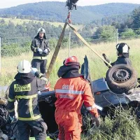 Preden so rešili voznika in sopotnika s prednjih sedežev, so morali gasilci avto privzdigniti