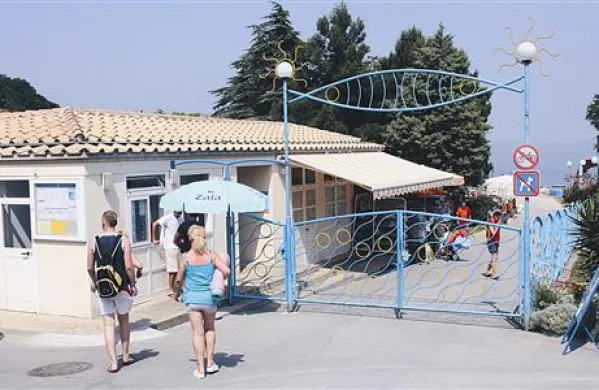   Prometni znak ob  vhodu na kopališče prepoveduje promet za  kolesa. Kolesar, ki kolo potiska ob sebi,  pa je v bistvu pešec.