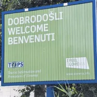 Promocijska tabla gostom izreka dobrodošlico v Slovenijo, zapuščen lokal nedaleč stran pa pri tem ni prav nič v pomoč