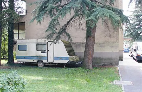 Parkiranje počitniške prikolice na zelenici ob bloku ni dovoljeno, razen če ima blok pripadajoče funkcionalno zemljišče