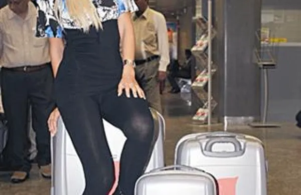 Misica s polnimi kovčki čevljev, oblek in daril