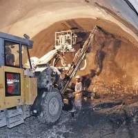 Prizor z  izolske strani, ko  skozi 25 do 35-centimetrsko plast brizganega betona   vrtajo v hrib, da  lahko vstavijo šestmetrska  sidra. To je  del statične konstrukcije predora. 
