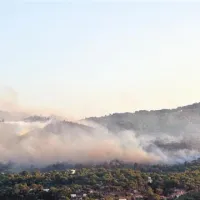 Požar, nad katerega leti gasilsko letalo canader, drugo (desno) pa se pripravlja na gašenje