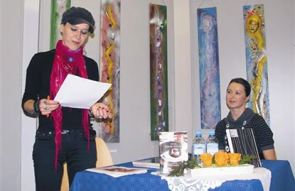 Patricija Dodič-Patra (levo) ob branju svoje poezije in ob svojih likovnih stvaritvah (v ozadju)