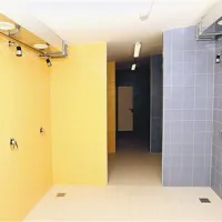 Vsaki slačilnici, ki je namenjena eni ekipi, pripada po osem tušev.