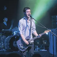 Pevec in kitarist zasedbe White Lies Harry McVeigh.