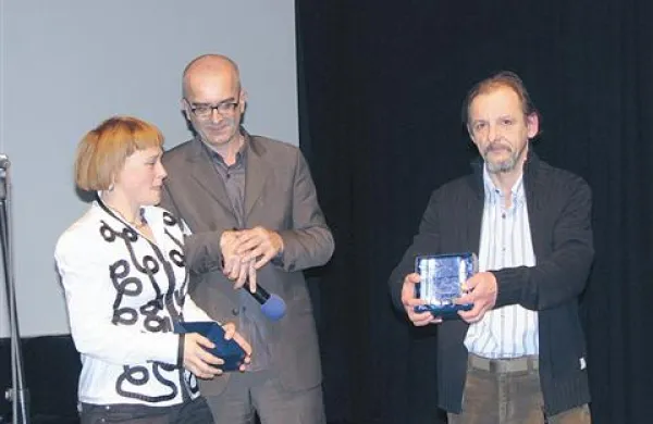 Miroslav Janek (desno) je nagrado prejel iz rok vodje srečanja Mateje Zorn (levo), med njima predsednik upravnega odbora Kinoateljeja Aleš Doktorič.  