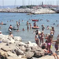 Na skalah v ospredju fotografije bi hotel Delfin zgradil pomol, nove dostope v morje in reševalni stolp
