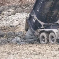 ... v katero tovornjak nato strese poltekoči mulj