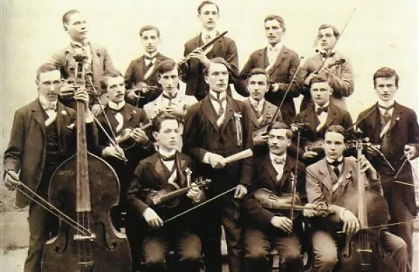 Orkester slovenskih učiteljiščnikov v Kopru iz leta 1906. V sredini stoji učitelj glasbe Ivan Sprachman, za njim v beli obleki Srečko Kumar (Vir: arhiv Gimnazije Koper)
