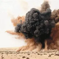 Protestnik ob eksploziji bombe, ki so jo odvrgli pripadniki Gadafijevih sil v puščavi blizu mesta  Brega.