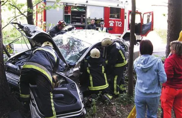 Lažje poškodovanemu vozniku so iz avomobila pomagali gasilci.
