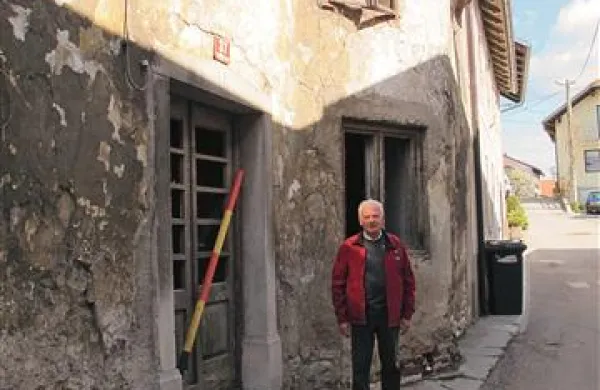 Marjan Geržina pred hišo, ki ima nad vrati letnico 1888. Nekdaj so v njej bivali lastniki, ki so prišli s Tirolske in so izdelovali ter popravljali instrumente. Hiša je že nekaj let prazna, ima okoli 20 lastnikov, ki živijo po vsem svetu.