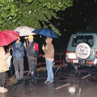 Domačini so se kljub dežju zbrali sredi vasi in z delavci cestnega podjetja prostor zaščitili