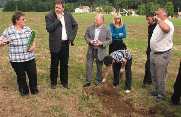 Svetovalka Dorica Drmota je pod uničeno rušo na plan brskala  ogrce majskega hrošča, minister Židan (drugi z leve) pa je obupanim kmetom obljubil pomoč