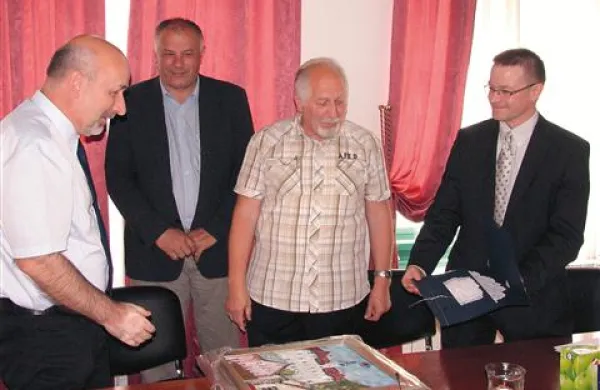   Župan Bojan Sever in člani šahovskega kluba Idrija so prvaku Šemrlu (prvi z leve) namenili  nekaj značilnih idrijskih daril