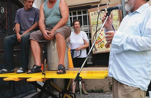 Arijana Markučič (zadaj) ob vokalni spremljavi Marka Breclja (desno) z ročnim viličarjem dviguje dva, brez katerih Kopergrounda ne bi bilo: Sava Volka, enega poslednjih mojstrov za Iskrine kinoprojektorje ter njegovega vajenca  Ivančka Peterleta (levo)  