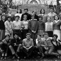 Veseli učenci osmega razreda podgrajske osnovne šole z razredničarko Jelko Butinar in ravnateljem Alojzom Kanclerjem ob koncu šolanja junija 1961.