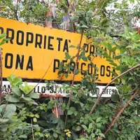 Edini napis, ki opozarja na to, da je območje “zasebna last” in da je “nevarno”, je obrnjen navznoter in prekrit z vegetacijo.