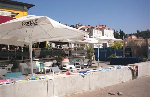 Bojan Salomon ima od Avditorija v najemu gostinski lokal Cafe teater v Piranu skupaj s teraso, vendar mize in glasbeni oder (na fotografiji desno)  postavi tudi na javno površino pod teraso. Naj bi imel za to “dovoljenje”, ker je pred leti na svoje stroške  uredil bližnjo peščeno plažo, za katero še vedno, kakor sam pravi,  skrbi. 