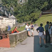 Na parkirišču pri Predjamskem gradu naj bi taksist med vzvratno vožnjo zbil ameriško turistko.