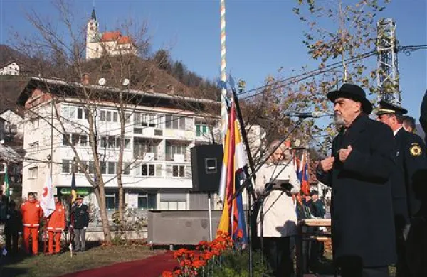 Akademik Ciril Zlobec in spomenik v ozadju