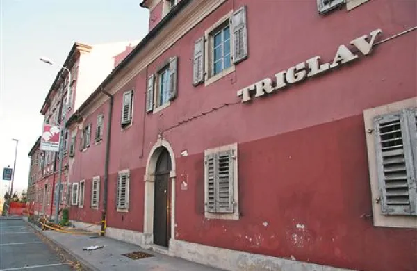 Hotel Triglav, dolga leta privlačen za turiste in celo kronane glave, zadnja leta   propada. Na strani ob cesti varnostni trak  opozarja mimoidoče pred možnimi okruški s strehe ali pročelja.