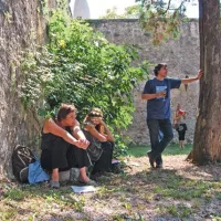 Profesorici Cergol in Ečimović na grajskem dvorišču sede, Cartarescu pa stoje in naslanjaje se …