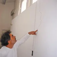 Gorazd Pretnar kaže na eno  od sten, kjer so dobro vidne razpoke, ki so nastale  zaradi miniranja na terminalu