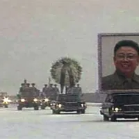 Črna limuzine na čelu sprevoda, na kateri je bil pritrjen ogromen portret smejočega se Kim Jong Ila. Za njo je avtomobil s krsto voditelja.