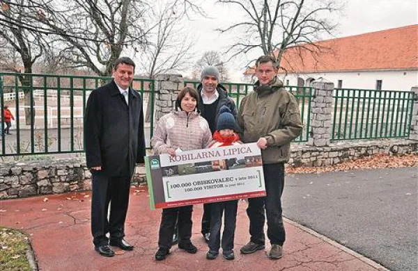 Katarina Juvančič Kogej se je v Lipici pred leti poročila, se z možem in sinom vrnila “na kraj dogodka” - in postala 100.000. obiskovalka Lipice v letu 2011. čestitala sta ji direktor   Tomi Rumpf (levo) in pomočnik direktorja za marketing in prodajo Bogdan Capuder  