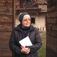 Dr. Alenka Goljevšček pred domačo hišo v Avberju na Krasu 
