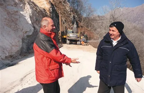 Poveljnik kobariške  CZ Marijan Stres in inšpektor Tadej Markič  na skoraj očiščeni cesti, ki jo je v petek zasulo 