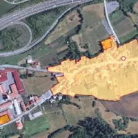 Zgornji zračni posnetek prikazuje vas Razdrto. Območje naselbinske dediščine so na ministrstvu za kulturo obarvali rumeno, na PN smo s piko  označili lokacijo nekdanje hiše.