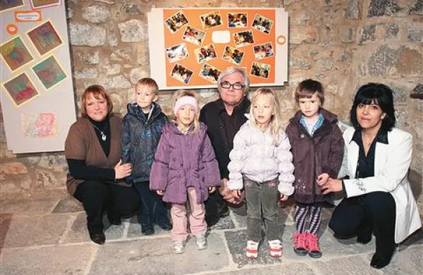 Vzgojiteljici Silvana Lozej (levo) in Denis Lemut ter Lado Leskovar z malčki skupine Račke na dobrodelni štanjelski razstavi