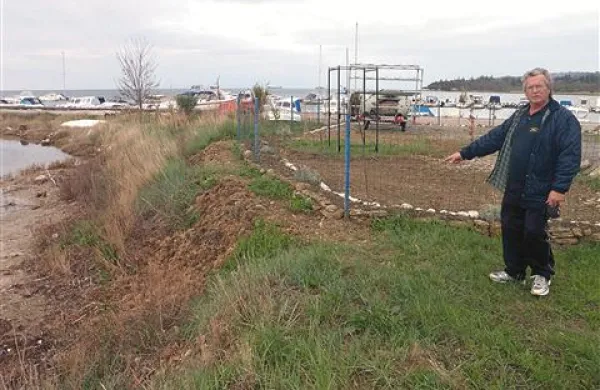 Vlado Jakomin kaže na prestavljeno ograjo Orke, ki je za nekaj metrov razširila svoje “dvorišče” in ob ograji pustila zgolj ozko potko, neprimerno za nošenje čolnov
