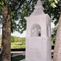 Prenovljeni pil na križišču poti v Vogljah, kjer je bila nekoč cerkev svetega Ivana. Na njem je napis v bohoričici iz leta 1852.