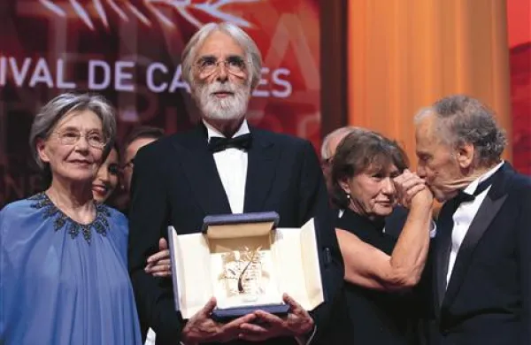 Režiser Michael Haneke je svojo drugo zlato palmo prevzel v družbi glavnih igralcev Emmanuelle Riva in Jean-Louisa Trintignanta
