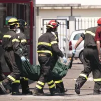 Reševalci v Medolli odnašajo truplo iz stavbe, ki jo je poškodoval potres