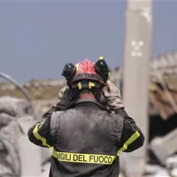 Reševalec pregleduje porušeno stavbo v Medolli