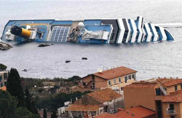 Turisti se v plitvini fotografirajo ob ladji, nato pa se tam kopajo ali sončijo na obali