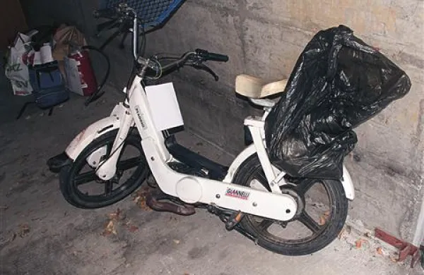 Moški  je vozil kolo z motorjem, znamke piaggio, bele barve