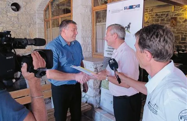 Graciano Prekalj (na fotografiji v sredini je Branimirju Radikonu (levo) izročil rejni program za istrsko govedo v slovenskem jeziku