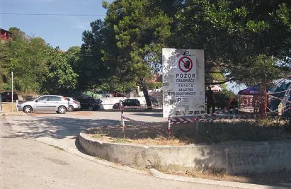  Plastični trakovi omejujejo parkirišče, tabla pa sporoča, da je tam gradbišče