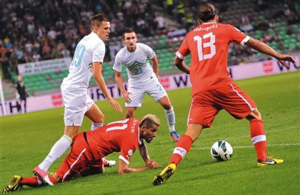 Na vrhu in na dnu: Švica (na fotografiji v rdečih dresih) ima po dveh krogih skupine E poln izkupiček, Slovenija pa je še brez točke 