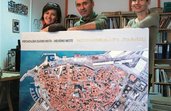Maša Sakara Sučević (desno), Zdenko Bombek in Neža Čebron Lipovec z zemljevidom Ne-vidnega mesta