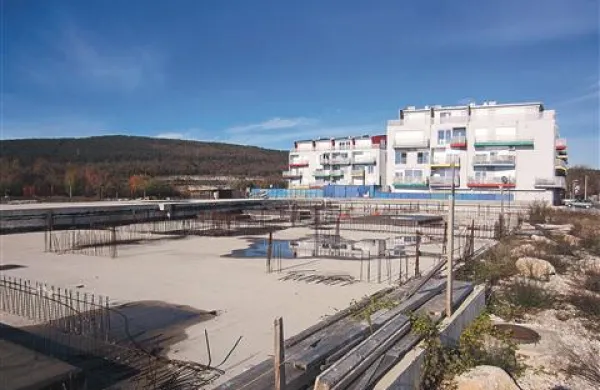 Iz velikega betonskega platoja novogradnje Brinje na Kozini  štrlijo številne žice, ob gradbišču ni zaščitne ograde, nikjer ni videti niti opozorilne oznake Pozor, gradbišče!, še manj pa table s podatki o gradbišču