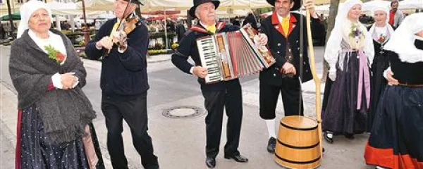Godci s tradicionalnimi glasbili - ob harmoniki vidimo škaf - dajejo takt plesalkam  