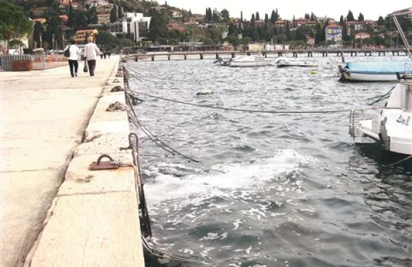 Pene se ob močni oseki pojavljajo ob obalnem zidu za Tivolijem v Portorožu